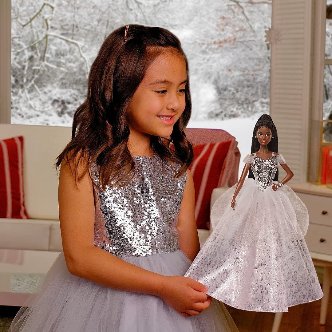 Child holding 2021 Holiday Barbie