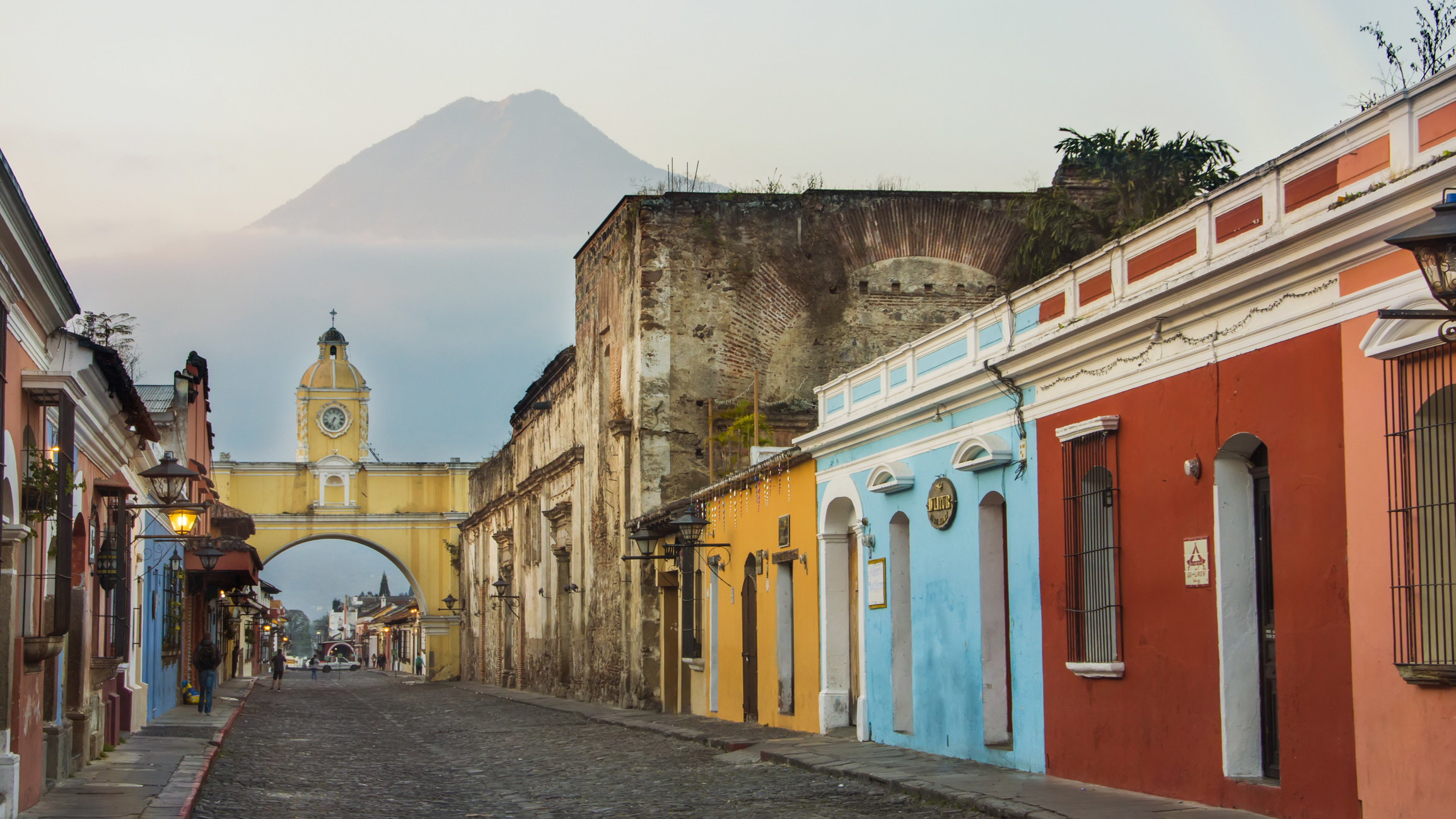Colorful buildings and a mountain in the backdrop of Antigua Guatemala.