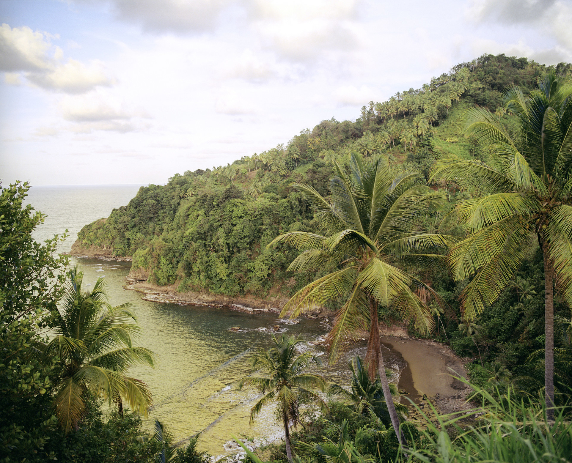 A view of the Atlantic ocean and coast above a beach in Dominica.