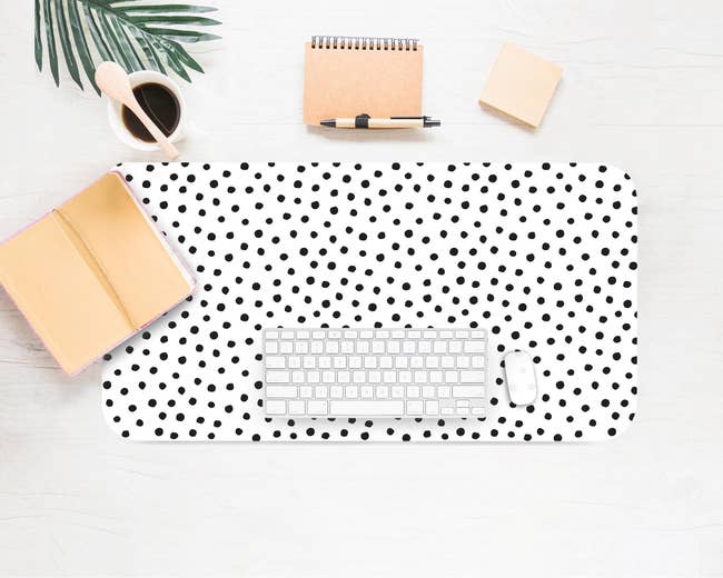 a product shot of the Dalmatian desk mat with a keyboard and mouse on top of it