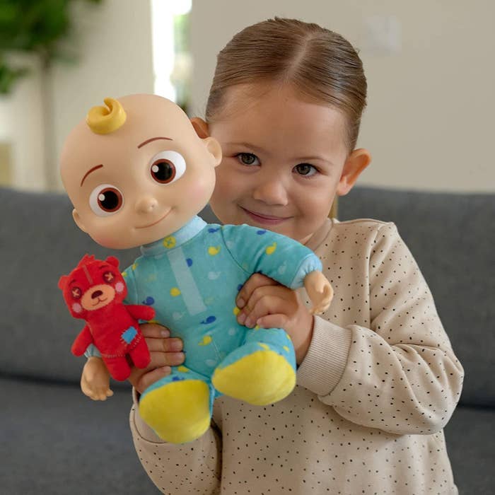 Child holding Cocomelon plush toy