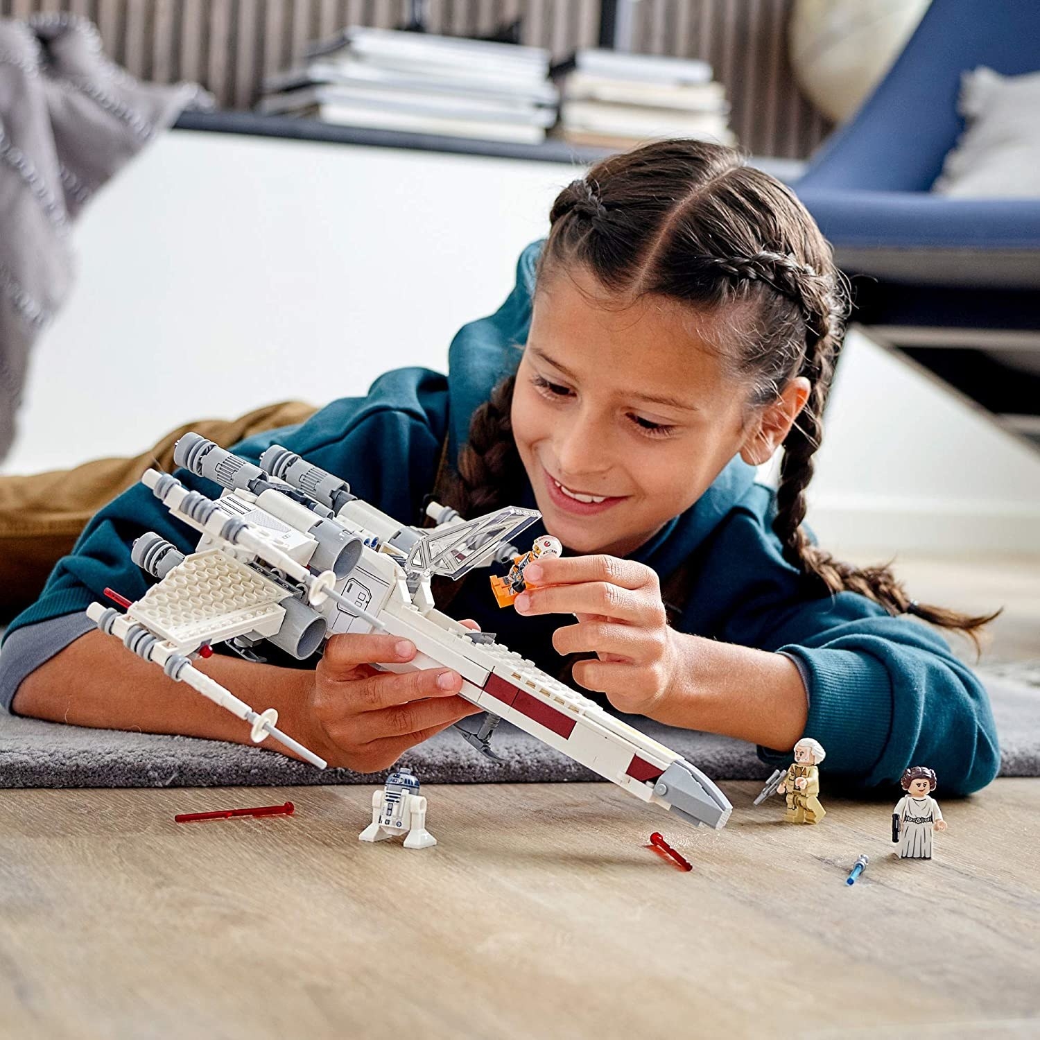 Child playing with Lego X-Wing Fighter