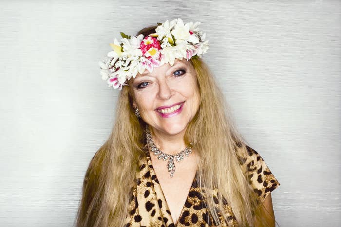 Carole wears a flower crown and animal print top