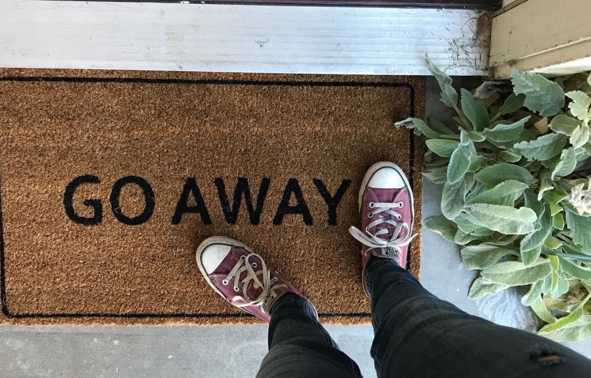 a reviewer shows the doormat that reads "go away" outside of their front door