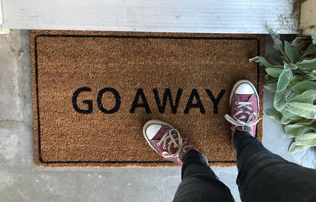 a reviewer shows the doormat that reads 