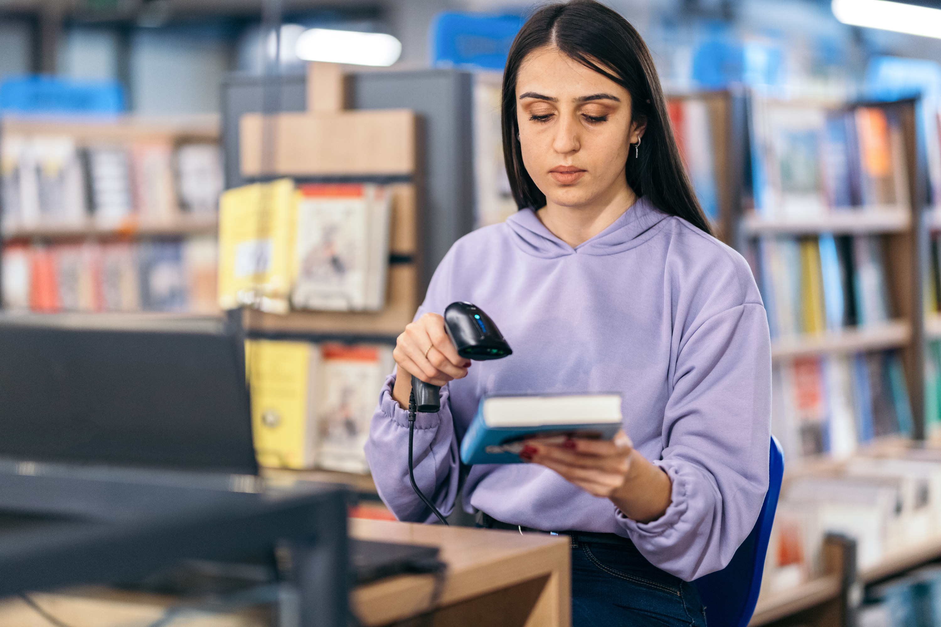 Person scanning a book in a library