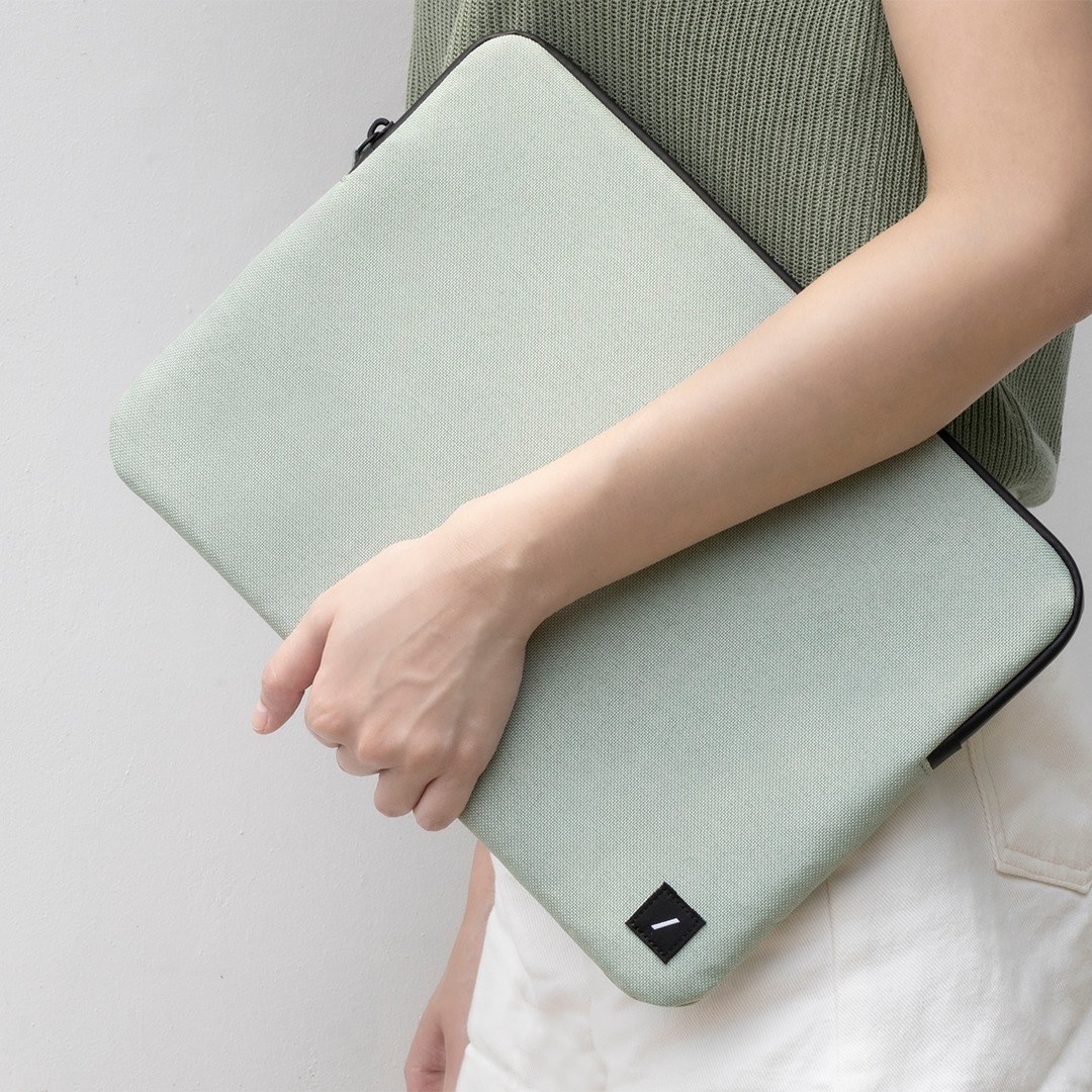 a person holding the laptop sleeve at their side