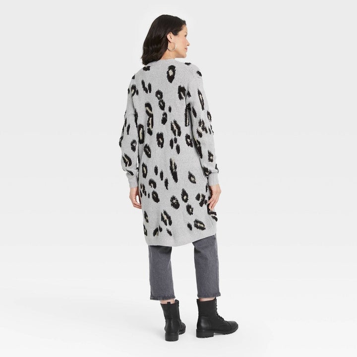 a model wearing the cardigan in gray leopard print and showing the back