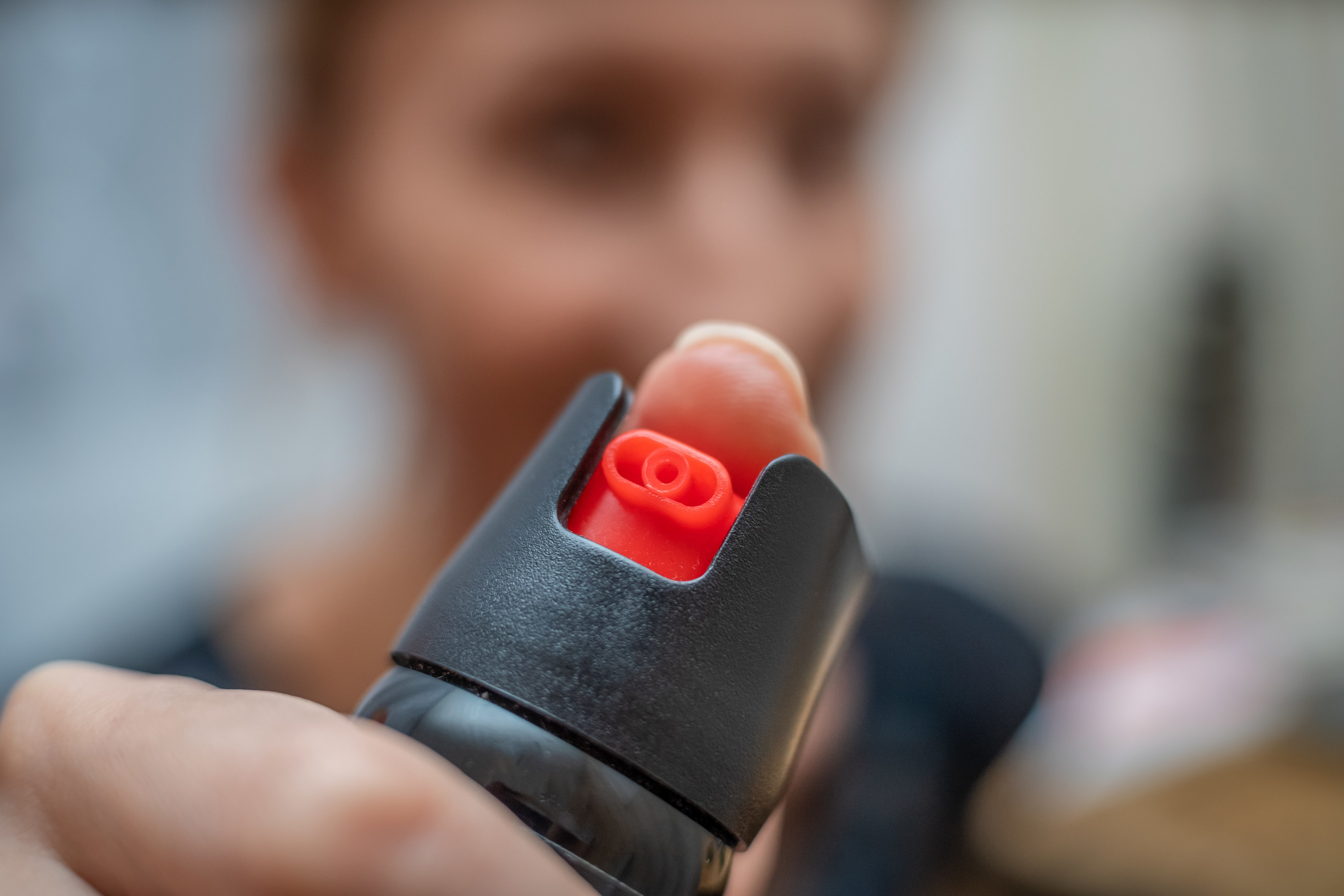 Person holding a canister of pepper spray