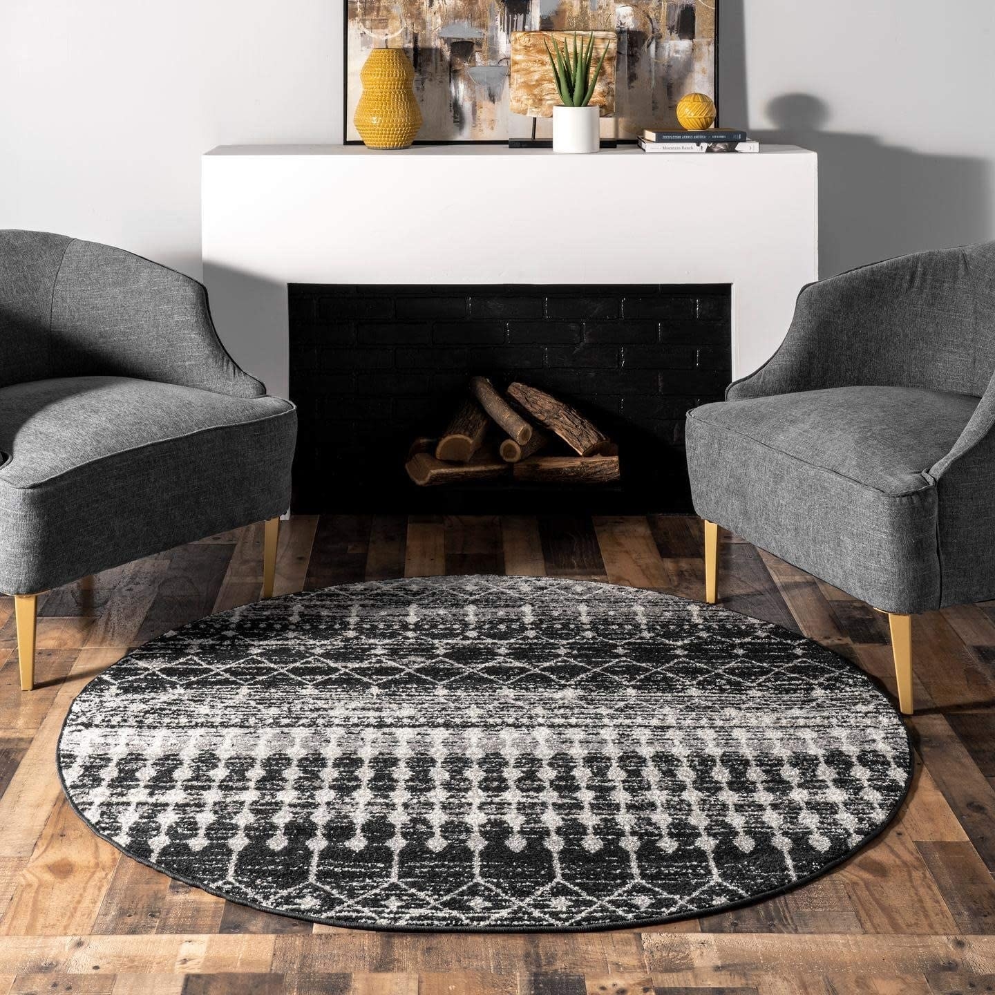 the round rug in black, white and gray with geometric shapes and line designs on it