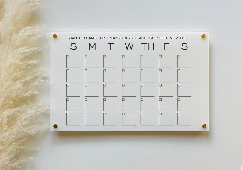 blank acrylic dry erase monthly calendar on a wall