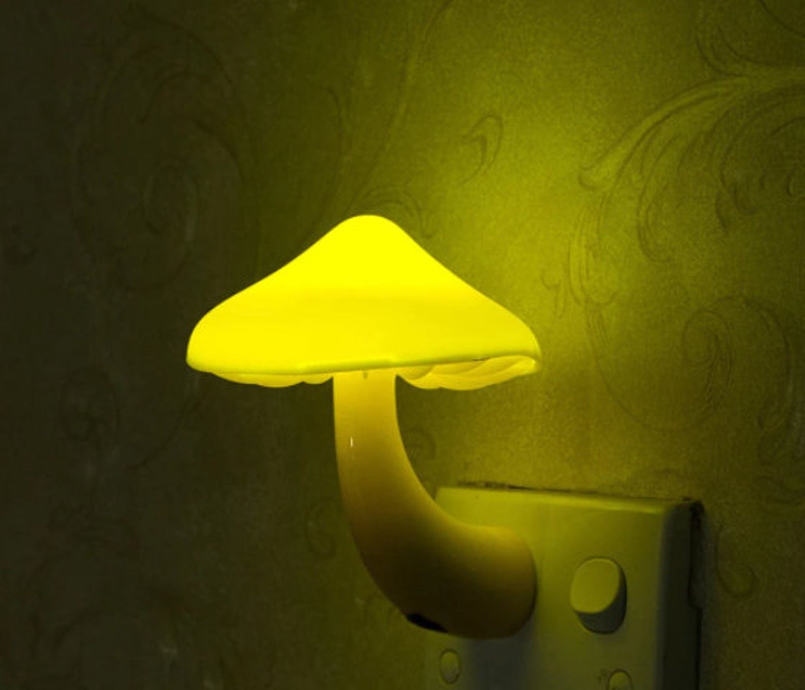 The mushroom nightlight lit up in a dark room