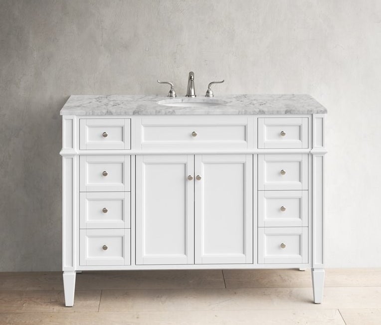 A white vanity with a marble counter top and nine drawers and two cabinets in the middle