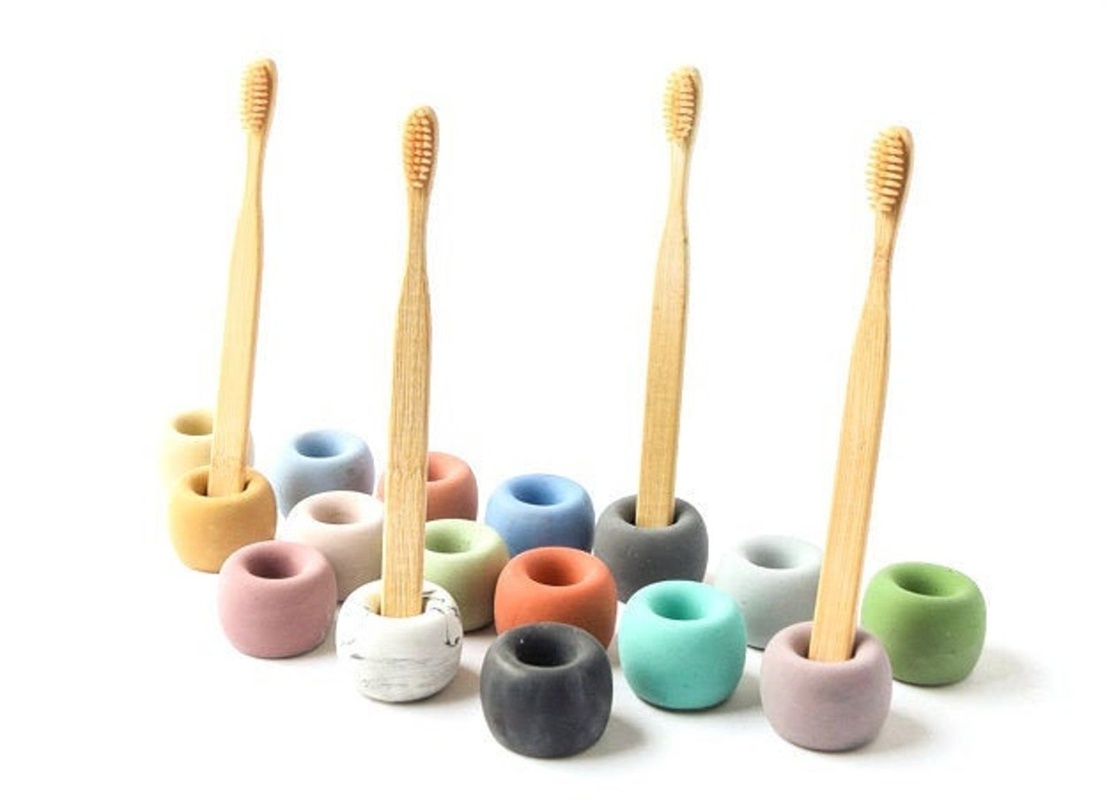 The toothbrush holders in many different colors holding bamboo toothbrushes