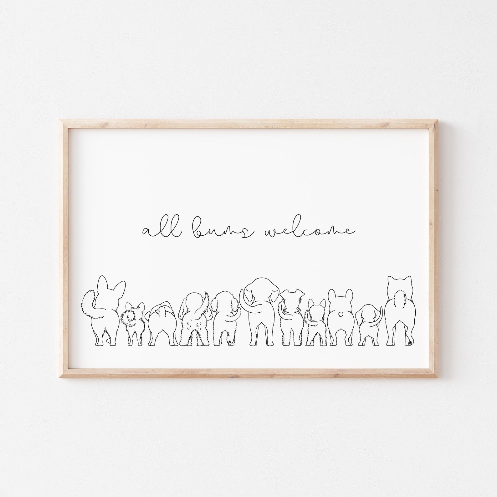 A framed print that shows a row of dogs&#x27; backsides with text: &quot;all buns welcome&quot;