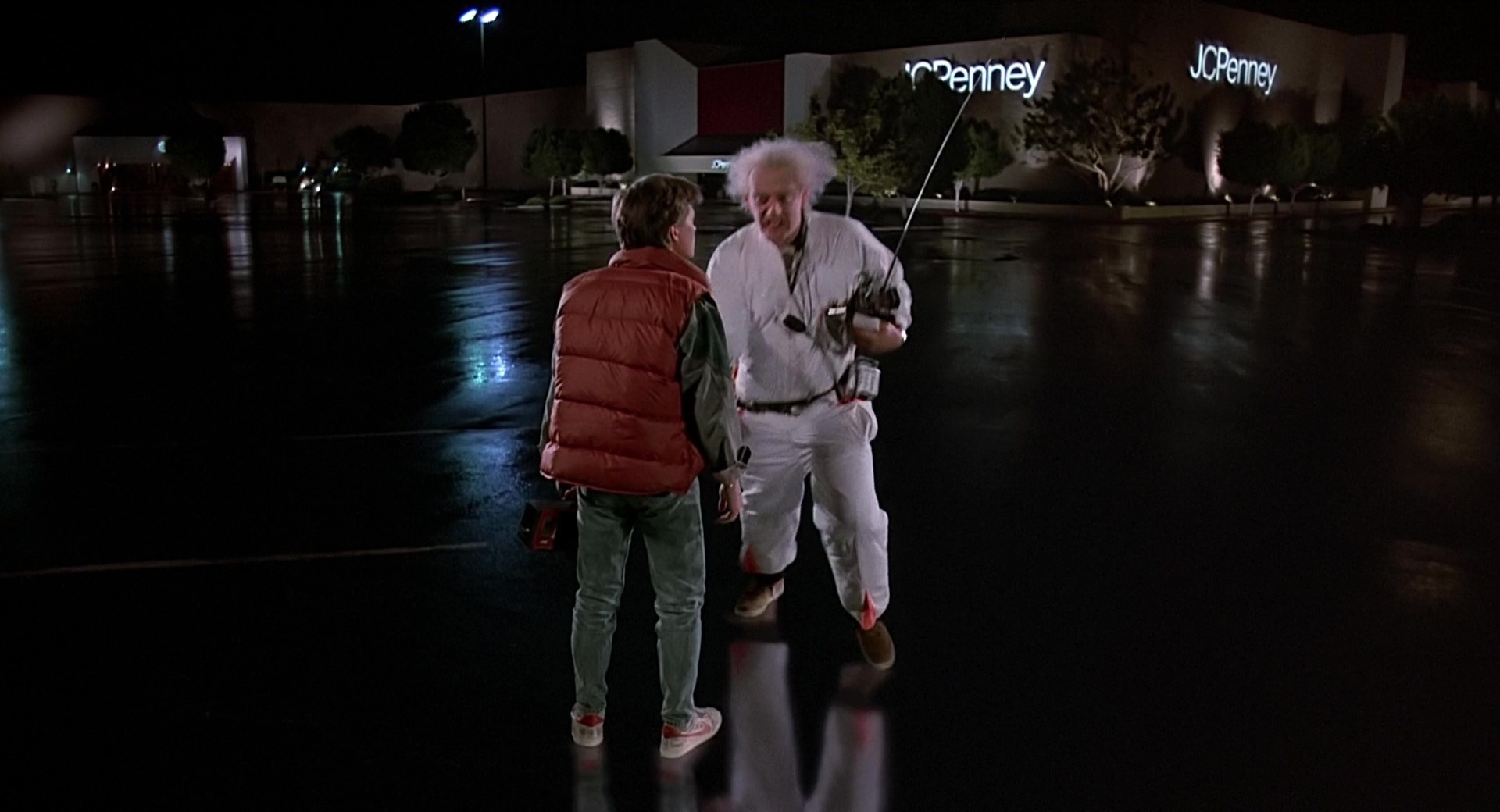 Michael J Fox and Christopher Lloyd stand in a mall parking lot