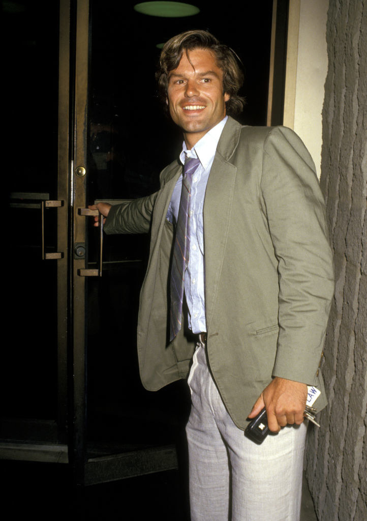 A young Harry holding a door open