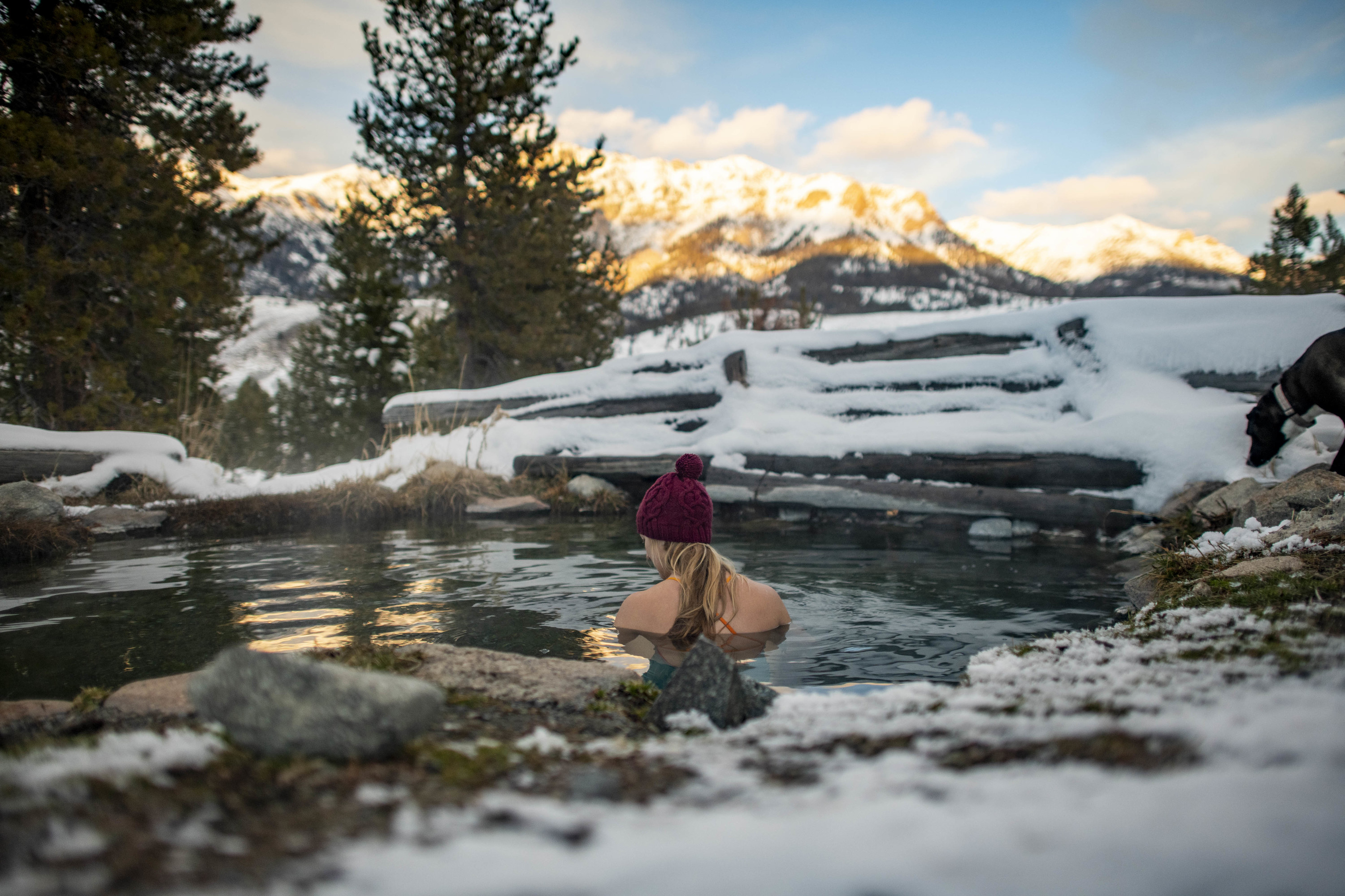 woman soaking in hot springs in the winter