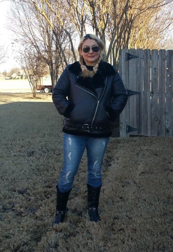 a reviewer in a black faux shearling coat