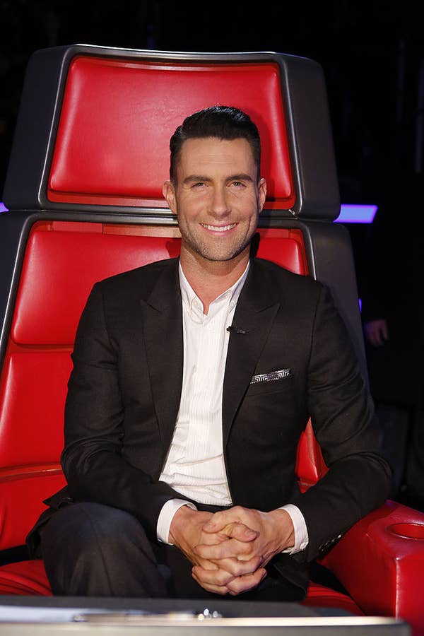 Adam smiles as he sits in chair on the voice sexiest man alive