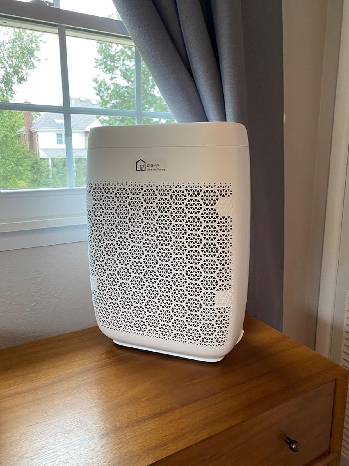 the air purifier sitting on top of a dresser