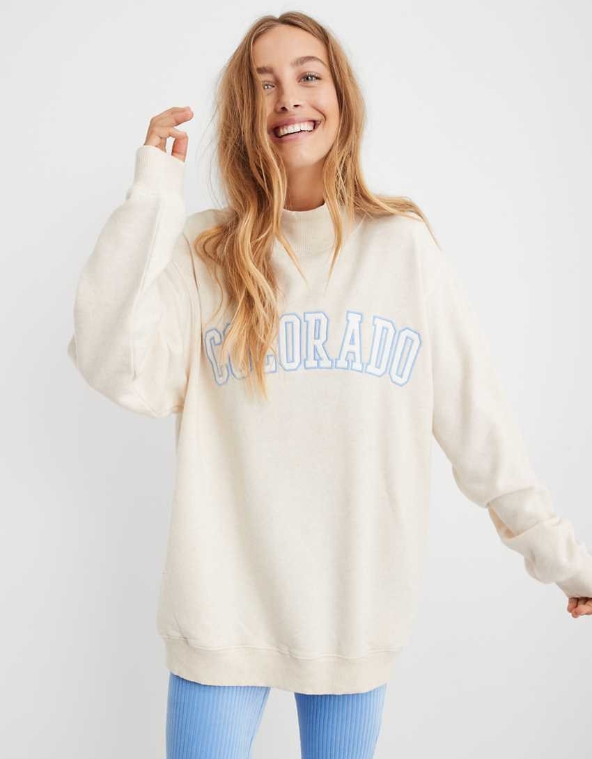 model wearing turtleneck sweatshirt in white with &quot;Colorado&quot; written on it