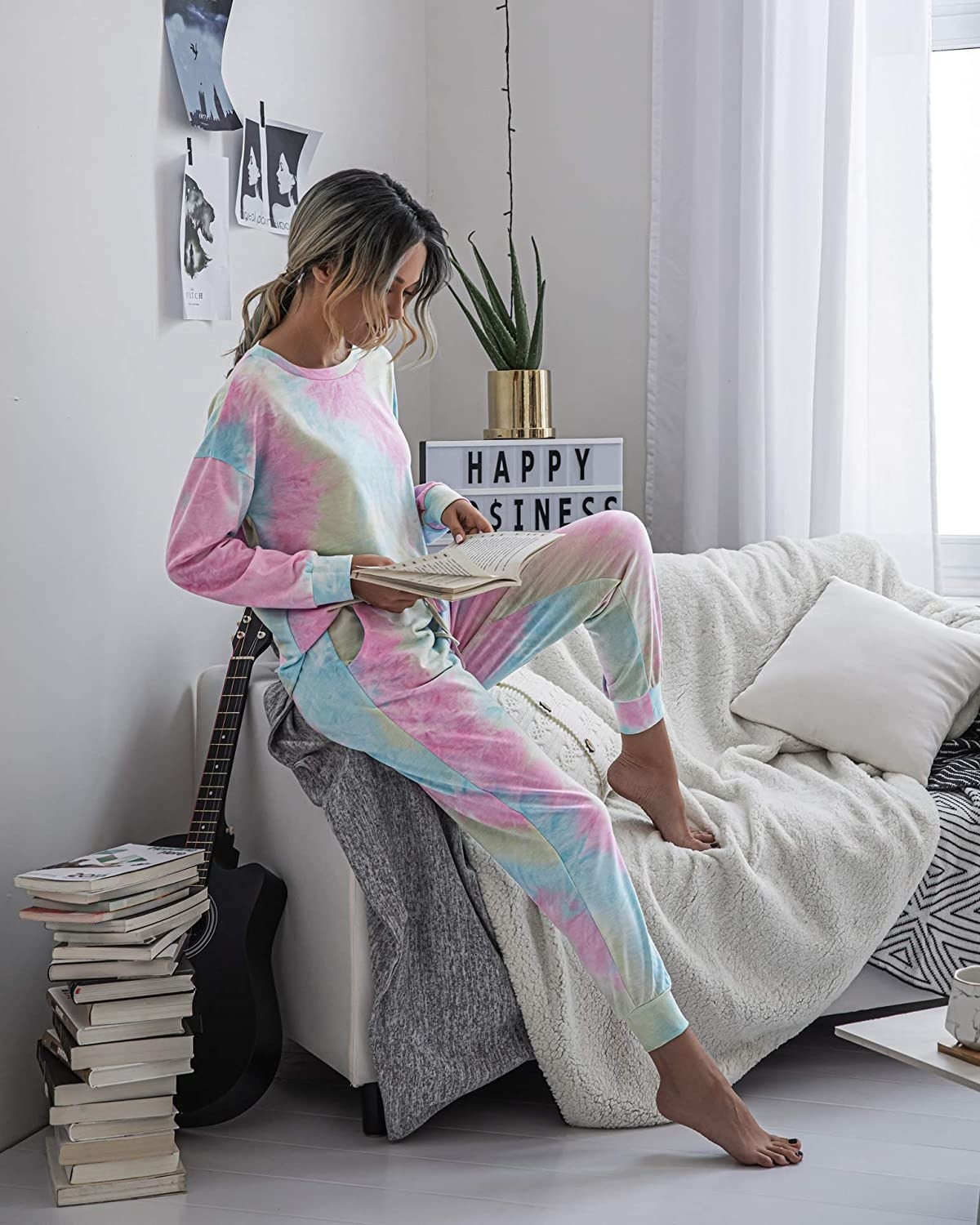 A model wearing the rainbow tie-dye set while sitting and reading a book