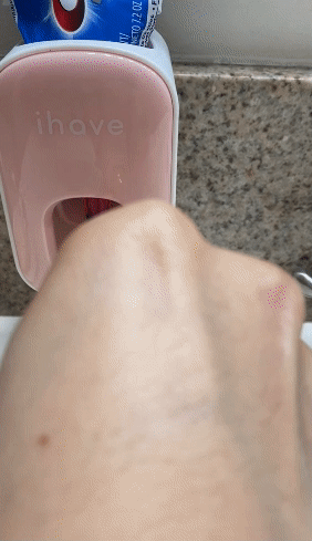 Reviewer GIF showing someone using the pink toothpaste dispenser to put toothpaste on a toothbrush
