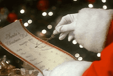 A vintage GIF of a pair of Santa hands looking through a paper that says &quot;Santa&#x27;s Christmas List&quot;