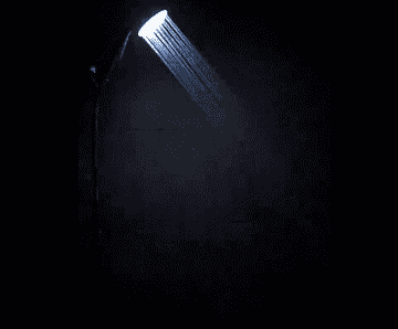 Reviewer GIF showing the shower head lights changing color in a dark bathroom