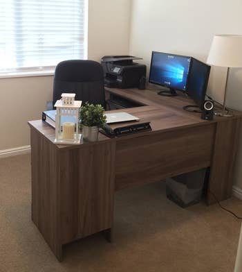 Reviewer's front of dark wooden desk with side panels and office chair