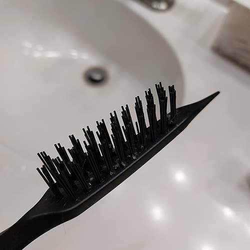 Reviewer's hair brush cleaner in hand