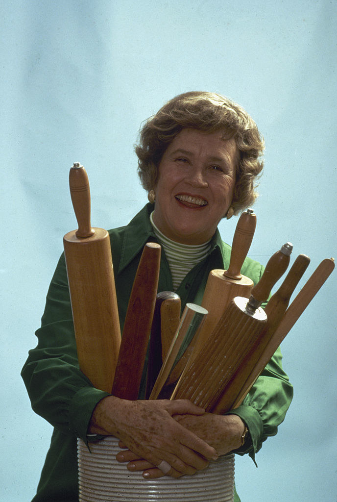 Child holding a bunch of rolling pins