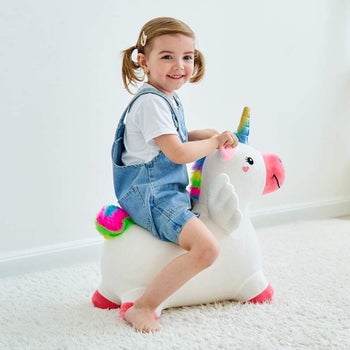 A child riding the toy unicorn