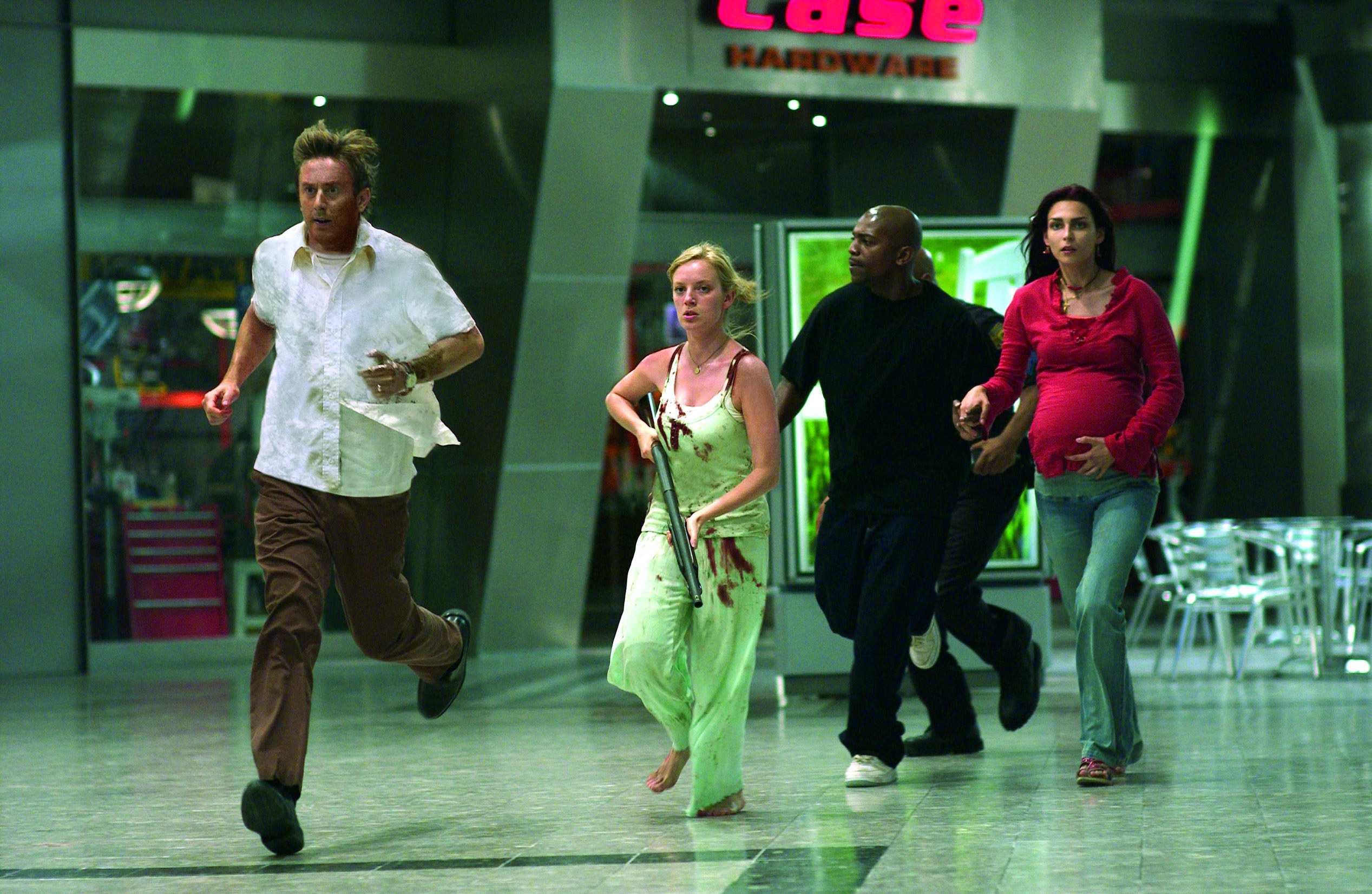 Jake Weber, Sarah Polley, Mekhi Phifer, and Inna Korobkina run through a mall