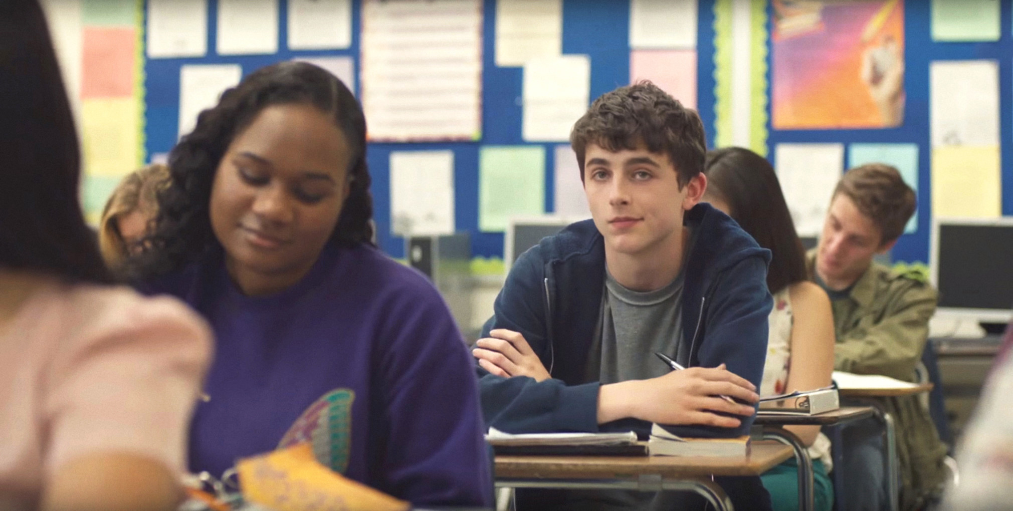 Timothee Chalamet sitting at his desk in a classroom among other students