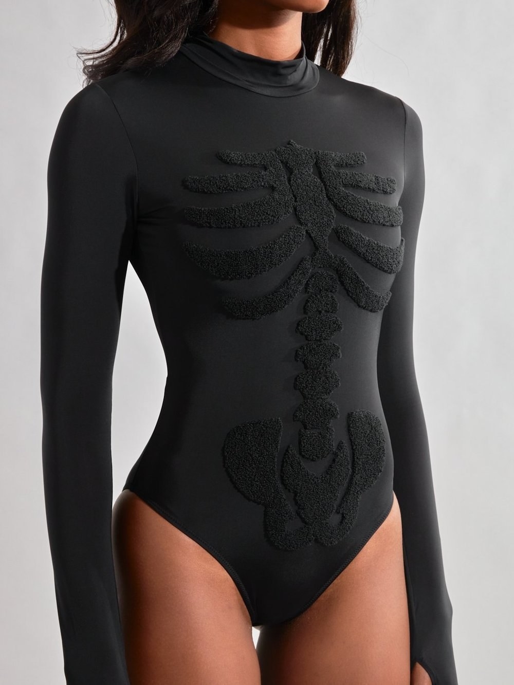 A model in the black mockneck bodysuit