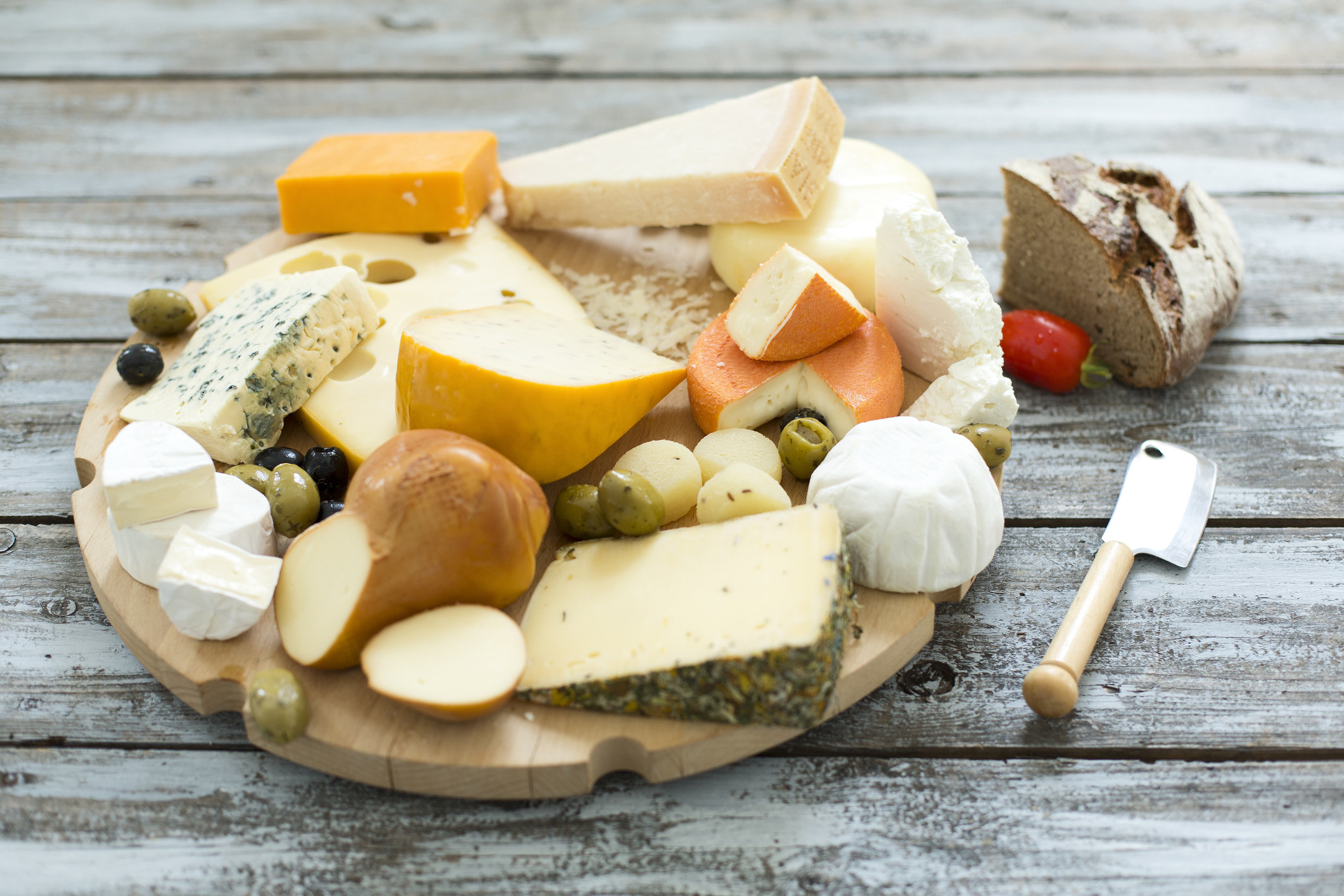 A wooden plate of various cheeses