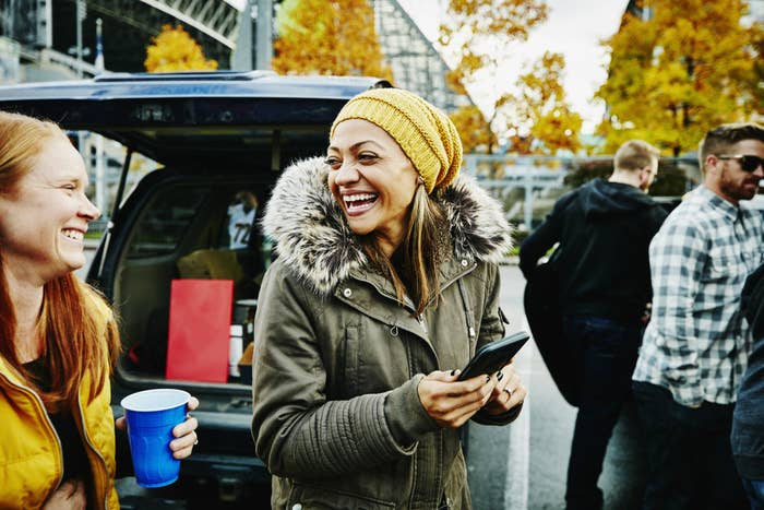 Two women outside at a tailgate party.