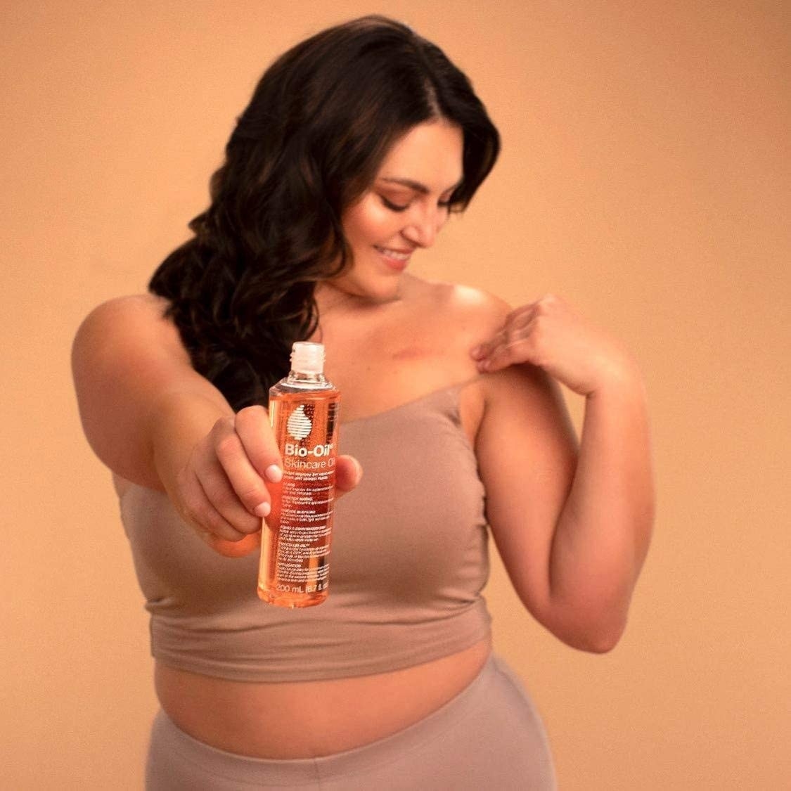 someone holding a bottle of the bio oil in their outstretched arm