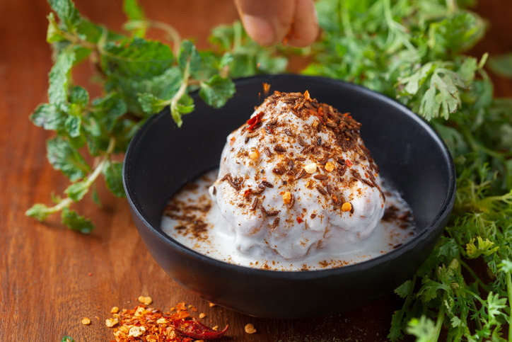 A bowl of keemar doi bora, garnished with chilli flakes and herbs