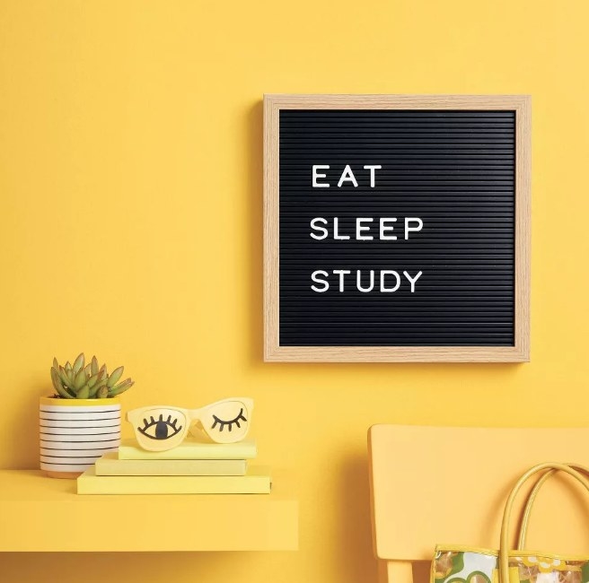 A black letterboard that reads eat, sleep, study mounted to a wall