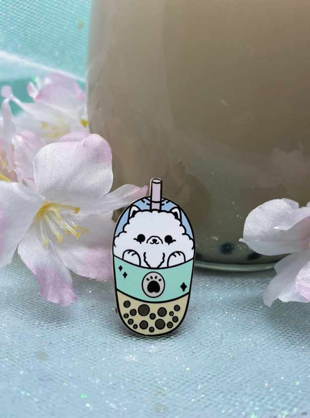 enamel pin of cute fluffy samoyed pup acting as whipped cream in bubble tea