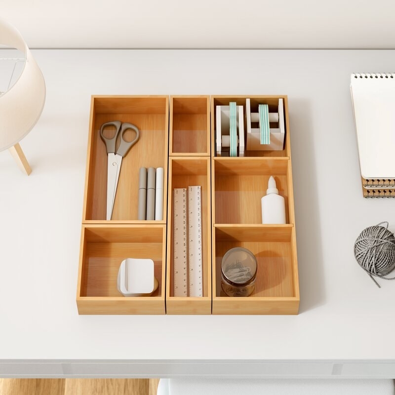 Five piece drawer organizer with assorted items inside
