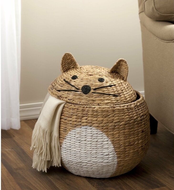 The woven cat shaped storage basket with a scarf inside