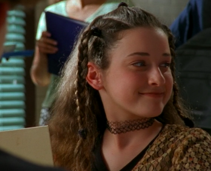 Margo with three braids in her hair and chokers necklaces on