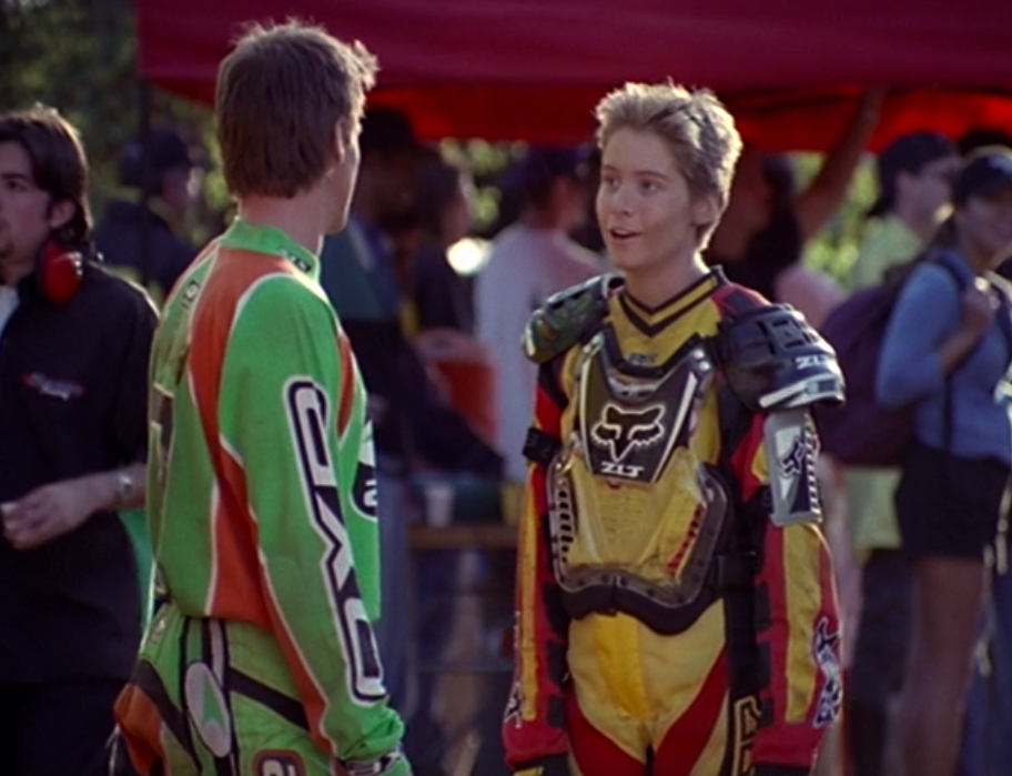 Alana with short, spiky hair wearing a racing uniform in &quot;Motocrossed&quot;