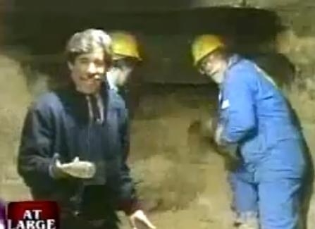 Geraldo Rivera speaks to the camera as workers mine what looks like a mysterious cave