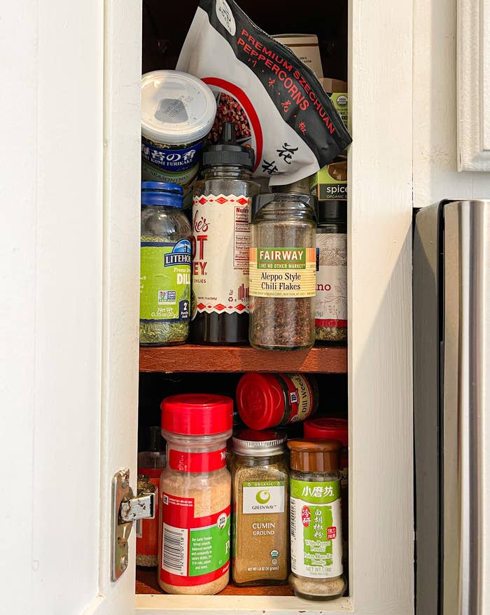 The author&#x27;s messy spice cabinet, full of disorganized spices that are mostly full.
