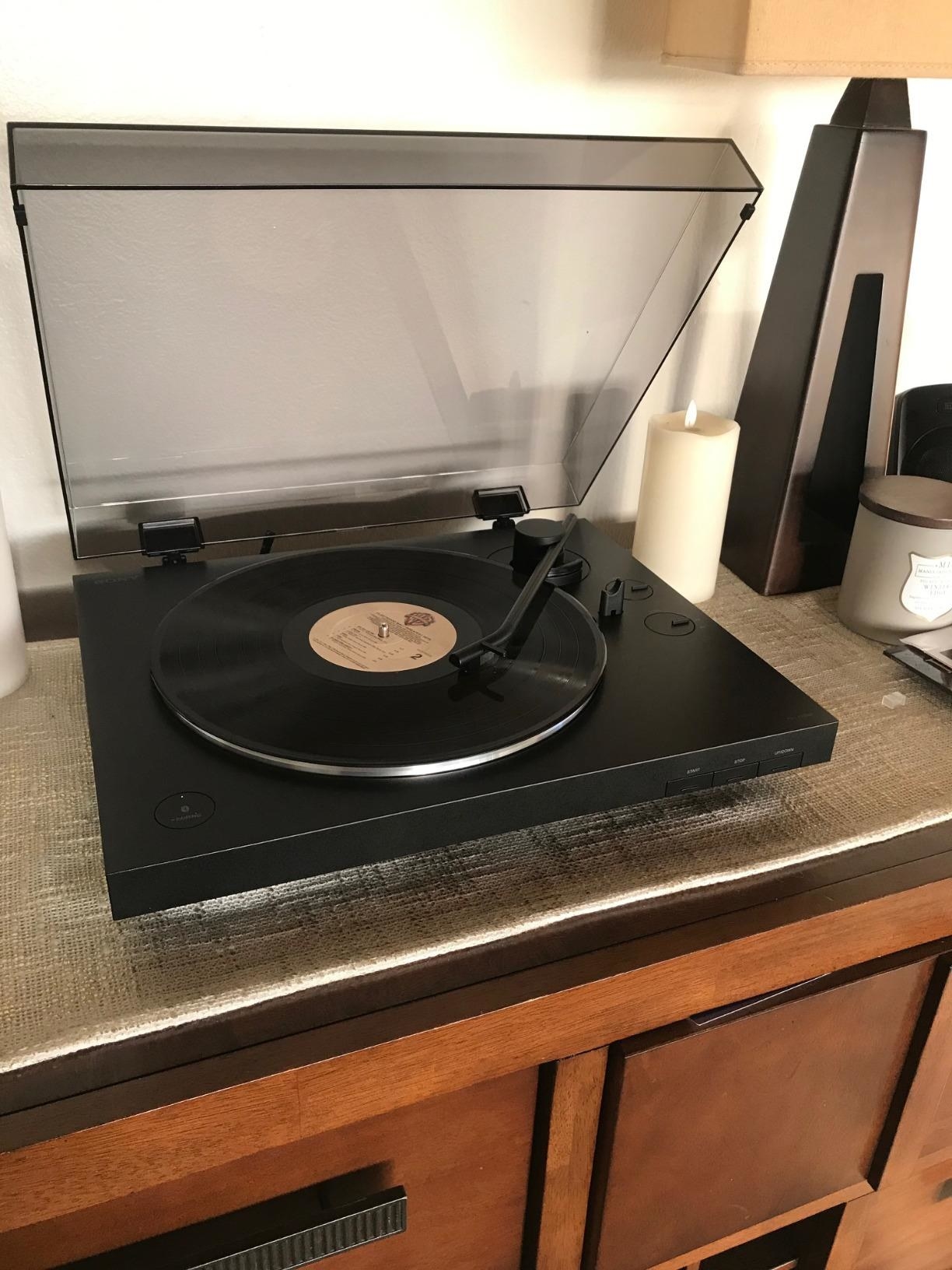 the wireless record player with a record in the the turntable and the top open